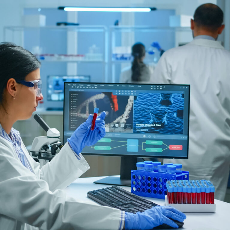 Group of scientists wearing lab coat working in laboratory while examining biochemistry sample in test tube and scientific instruments. Science technology research and development study concept